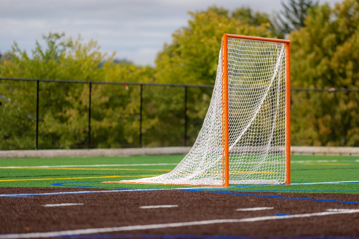 Lacrosse goal on a turf field with dramatic clouds